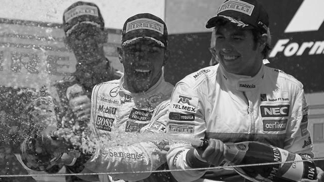 McLaren Formula One driver Lewis Hamilton (C) of Britain and third placed Sauber Formula One driver Sergio Perez of Mexico spray champagne during the podium ceremony following the Canadian F1 Grand Prix at the Circuit Gilles Villeneuve in Montreal June 10, 2012. Hamilton won the Canadian Grand Prix for McLaren on Sunday to become the seventh different winner in seven Formula One races this season.  REUTERS/Mathieu Belanger (CANADA  - Tags: SPORT MOTORSPORT TPX IMAGES OF THE DAY)