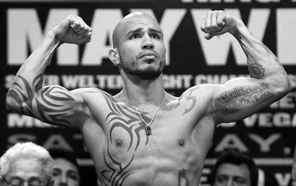 WBA super welterweight champion Miguel Cotto of Puerto Rico flexes on the scale during an official weigh-in at the MGM Grand Garden Arena in Las Vegas, Nevada May 4, 2012. Cotto will defend his title against Floyd Mayweather Jr. of the U.S. at the arena on May 5. REUTERS/Steve Marcus (UNITED STATES - Tags: SPORT BOXING)