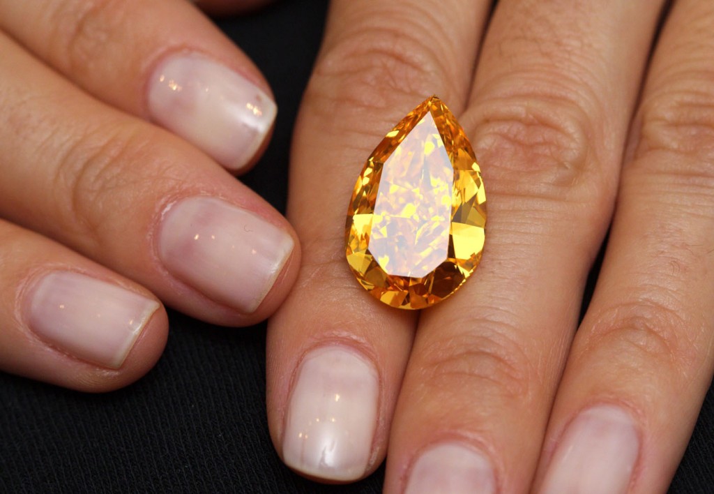 A Christie's member of staff displays "The Orange", the world biggest orange diamond during an auction preview in Geneva