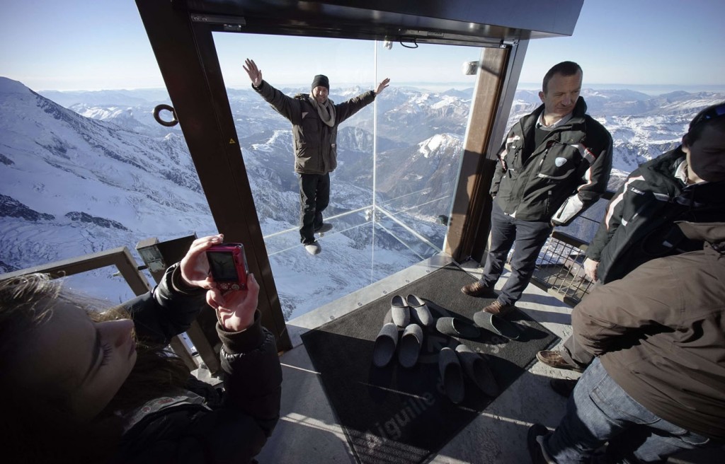 Journalists and employees visit the 'Step into the Void' installation as they attend a press visit at the Aiguille du Midi mountain peak above Chamonix, in the French Alps