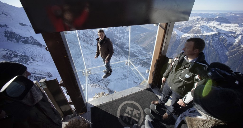 Journalists and employees stand in the 'Step into the Void' installation at the Aiguille du Midi mountain peak above Chamonix, in the French Alps