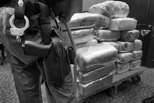 Foto tomada el 4 de noviembre del 2010 durante una rueda de prensa en Jonesboro, Georgia, en la que fueron exhibidos paquetes de marihuana. En esa operación 45 personas fueron arrestadas y fueron confiscadas varias armas y dinero en efectivo, como parte de una investigación sobre la penetración del cartel La Familia en Estados Unidos. Los carteles mexicanos del narcotráfico rara vez se aventuran del otro lado de la frontera, pero desde hace un tiempo están despachando algunos de sus mejores agentes para que vivan y trabajen adentro de Estados Unidos, reforzando su presencia en lo que algunos expertos consideran un esfuerzo por acentuar su control sobre el mercado de narcóticos más lucrativo del mundo y aumentar sus ganancias. (Foto AP/Atlanta Journal-Constitution, John Spink)